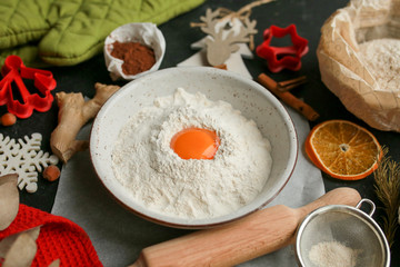 The process of making christmas cookies. Girl hands make the dough. Ingredients for baking a pie: flour, confectionery, dishes, kitchen utensils, spruce cookies figure on a dark background.Christmas g