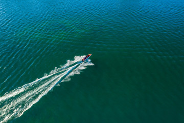 Aerial image of tourist speed boat on moving at clear blue sea at Waterfront Kota Kinabalu, Sabah, Malaysia