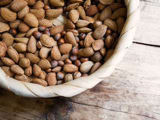 a large craft plate with raw natural nuts on a wooden vintage table, close-up