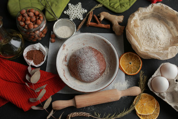 The process of making christmas cookies. Girl hands make the dough. Ingredients for baking a pie: flour, confectionery, dishes, kitchen utensils, spruce cookies figure on a dark background.Christmas g