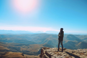 Fototapeta premium A young man is standing on a cliff. Caucasian ridge. Mountain landscape. sunny day