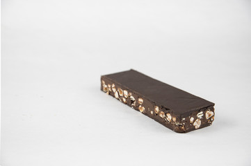 Chocolate and hazelnut nougat on a white background. Copy space. Sweet Christmas. - Image