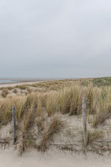  Dünenlandschaft am Strand mit Blick aufs Meer bei bewölkten Himmel