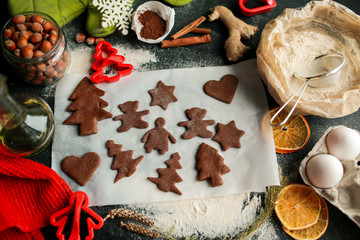 The tradition of celebrating Christmas and New Year. Home bakery cooking traditional holiday sweets. Woman cuts cookies from raw gingerbread dough. Prepare ginger and chocolate cookies together.