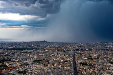 Eiffel tower encounters a heavy summer storm with Paris city view
