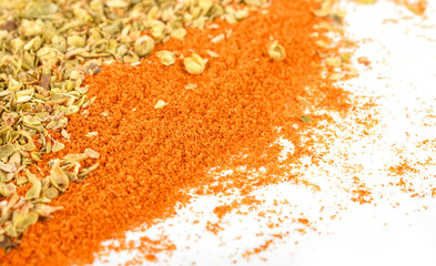 Pile of red paprika powder and Dried Oregano on white background
