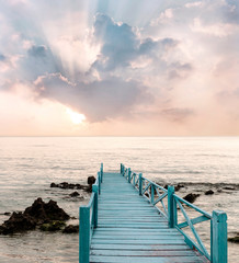 Fototapety  Drewniany most nad morzem, który ma drogę do podróży z pięknym tłem nieba i słońca.