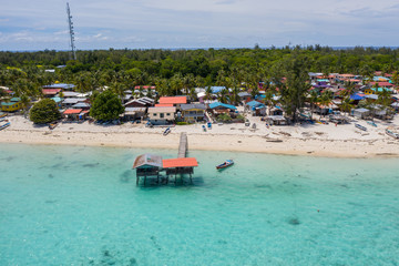 Fototapeta na wymiar Aerial drone image of beautiful white sandy beach tropical island with turquoise sea water and Malay traditional fisherman village at Mantanani Island, Sabah, Borneo - Travel Concept