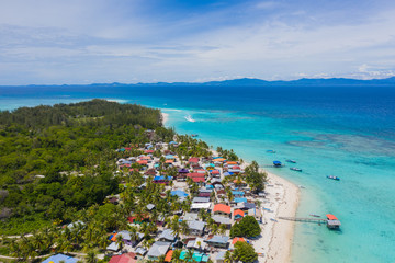 Aerial drone image of beautiful white sandy beach tropical island with turquoise sea water and Malay traditional fisherman village at Mantanani Island, Sabah, Borneo - Travel Concept