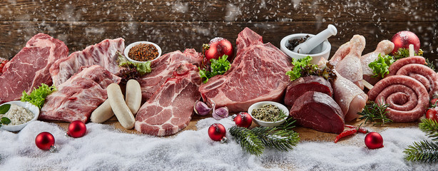 Christmas banner with assorted raw meat for a BBQ