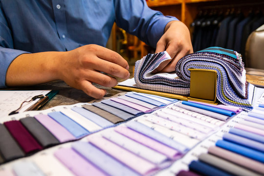 tailor choosing a fabric in swatch for his customer