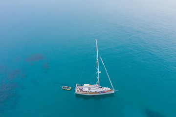 Fototapeta premium Aerial view of white Yacht in deep blue sea with beautiful landscape view in Kudat, Sabah, Borneo