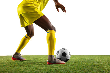 Professional african-american football or soccer player of yellow team in motion isolated on white...