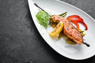 Baked salmon steak with potatoes and vegetables. Top view. Free space for your text.