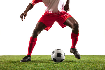 Professional african-american football or soccer player of red team in motion isolated on white studio background. Fit man in action, excitement, emotional moment. Concept of movement at gameplay.