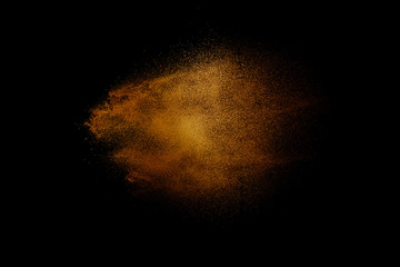 Fototapeta na wymiar Yellow powder explosion cloud on black background. Freeze motion of color dust particles splashing.