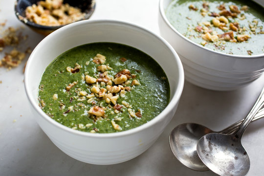 Spinach soup garnished with nuts served in bowls