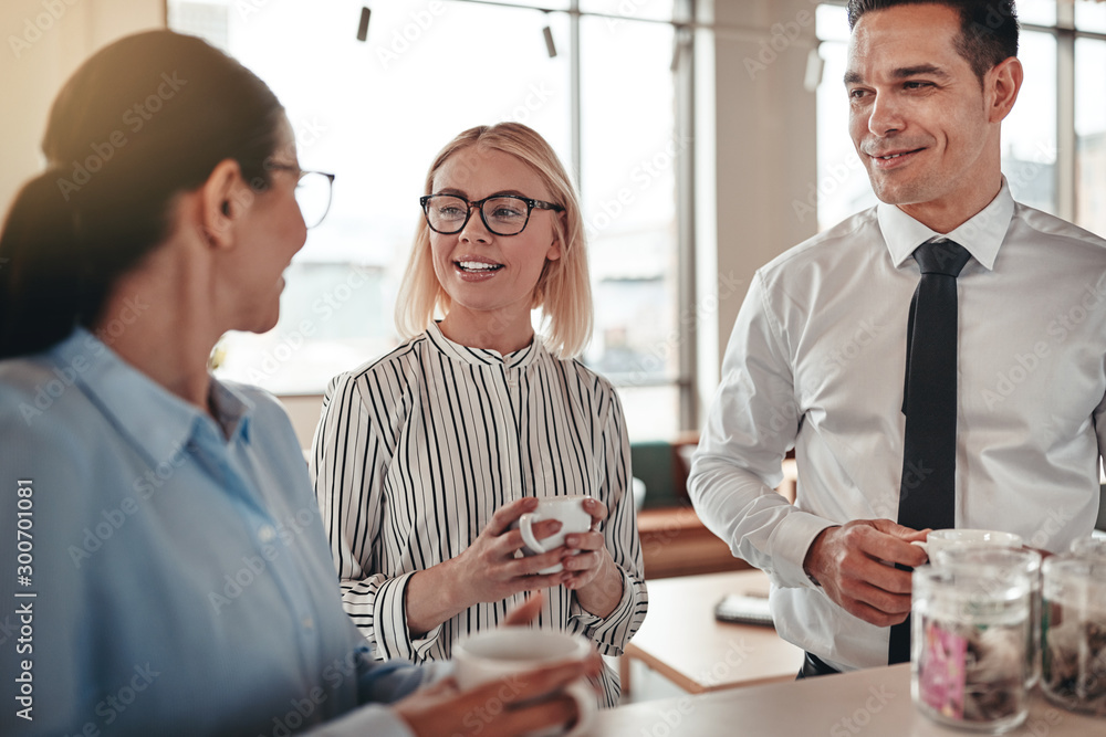 Wall mural smiling businesspeople talking during their office coffee break