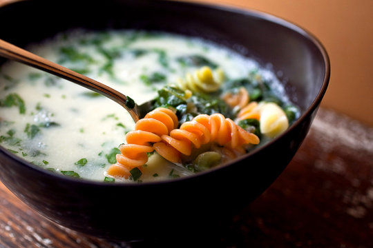 Close up of garlic soup with pasta served in bowl