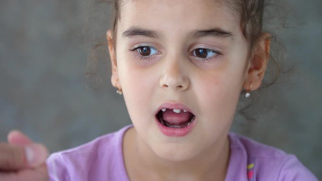 The hands of an adult pull the thread tied to the child's tooth. Failed attempt to remove a tooth. Pull out the tooth with a thread. Remove the tooth at home. Close up