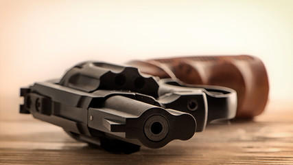 Obraz premium Black revolver front view lying on wooden surface