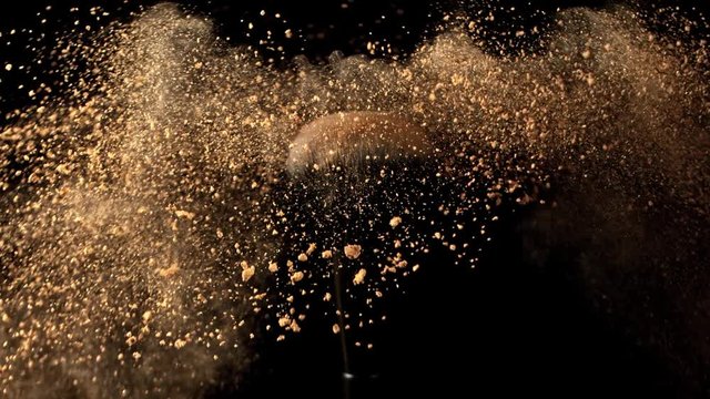 Super Slow Motion Closeup Shot of Makeup Powder Falling from Facial Brush at 1000fps.
