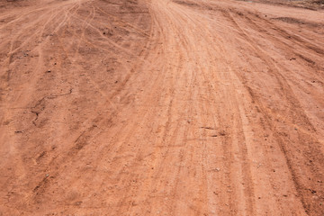 Curved rut background texture on hard dry dirt road