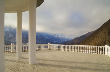 Triumphal rotunda of Sharvili with terrace and balustrade. Scenic view of dramatic sky and mountain range spur. Sharvili - hero of the Lezghin epos. Nature and travel. Russia, North Caucasus, Dagestan