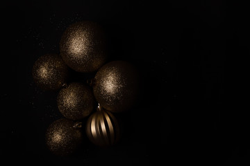 Christmas golden balls, in a dark, on a black background. copy space