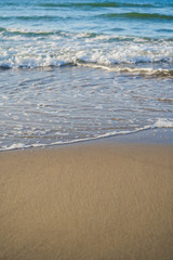 azure waves roll onto the sand of a beach on a sunny day, wallpapers for mobile devices
