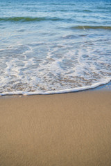 azure waves roll onto the sand of a beach on a sunny day, wallpapers for mobile devices