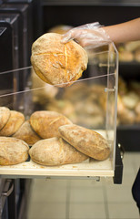 Female hand choosing bread in supermarket. Concept of healthy food, bio, vegetarian, diet.