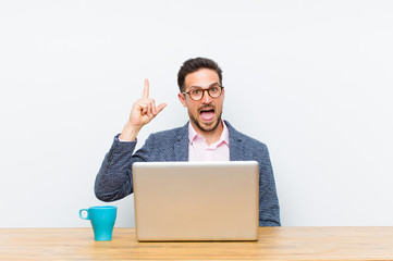young handsome businessman feeling like a happy and excited genius after realizing an idea,...