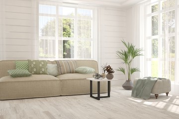 Fototapeta premium Stylish room in white color with sofa and summer landscape in window. Scandinavian interior design. 3D illustration