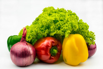 Green salad, red, yellow and green bell peppers, purple-red onions isolated on a white background.
