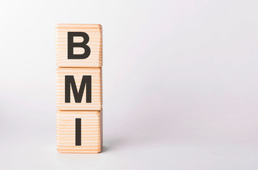 BMI letters of wooden blocks in pillar form on white background, copy space