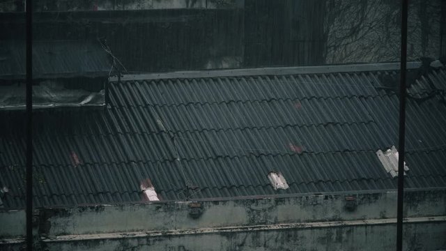 Fuerte lluvia sobre techos de chapas en una fabrica