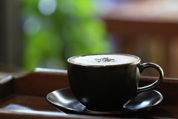 Cup of cappuccino with latte art on wooden background. Latte Coffee art on the wooden table. cup of coffee on table in coffee shop cafe