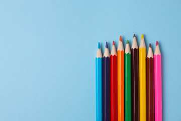 Multiсolored pencils on a blue background