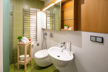 Modern light interior of bathroom. Toilet, mirror and sink.