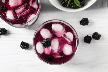 Delicious blackberry lemonade on white wooden table, top view
