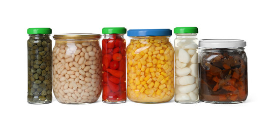 Different jars with pickled vegetables on white background