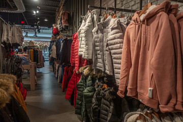 Store rack with warm clothing: winter coats and light down  jackets.