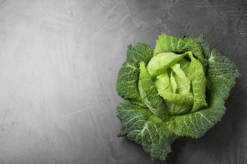 Fresh green savoy cabbage on grey table, top view. Space for text