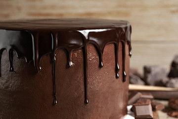 Freshly made delicious chocolate cake against blurred background, closeup