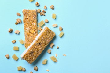 Healthy granola bars on blue background, flat lay. Space for text