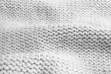 Grey knitted sweater as background, closeup view