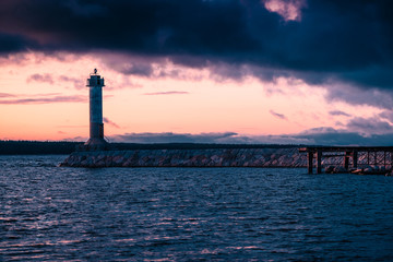 Stunning long exposure landscape lighthouse at sunset with calm. Water.