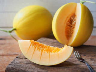 Yellow melon fruit sliced on wooden chopping board for eating healthy food concept.