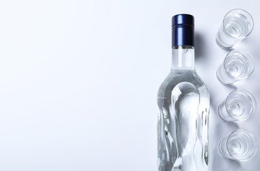 Bottle of vodka and shot glasses on white background, flat lay. Space for text - obrazy, fototapety, plakaty